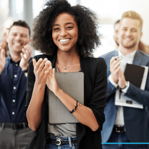 Woman at business meeting clapping excitedly, happy about affordable group health insurance