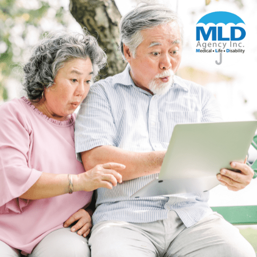 Older couple looking intrigued while researching Medicare Advantage plans with guidance from Mark Dupré, a Medicare expert, on their laptop.